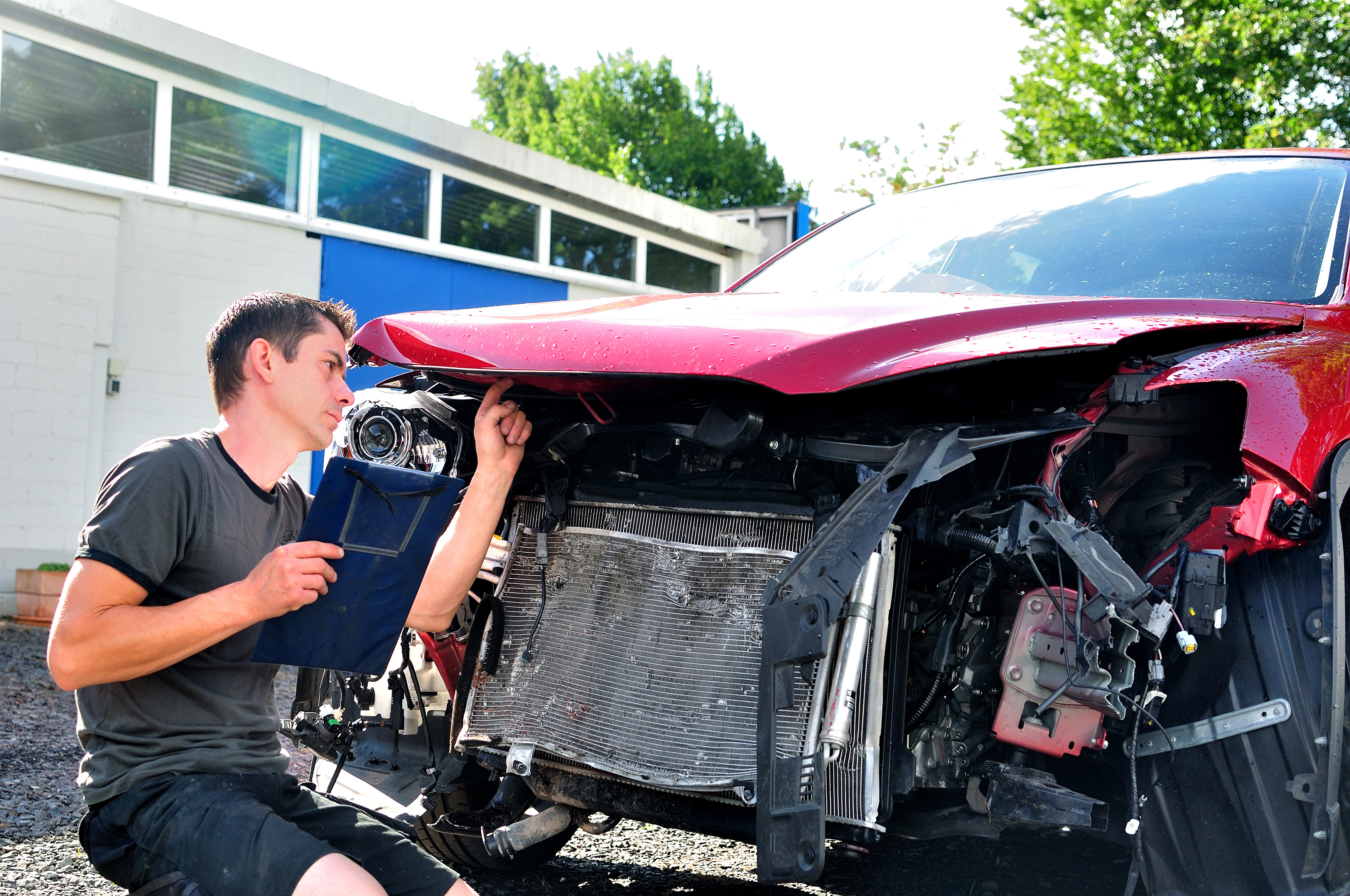 Engineer inspecting a damaged car